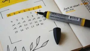 Cahier de planification ouvert avec marqueur, idéal pour organiser sa rentrée scolaire.
