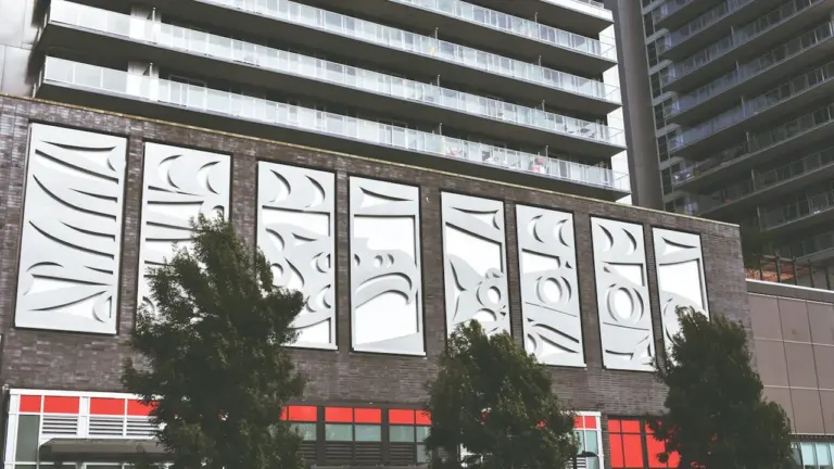 Facade moderne d'un immeuble urbain avec des panneaux artistiques abstraits à Surrey.