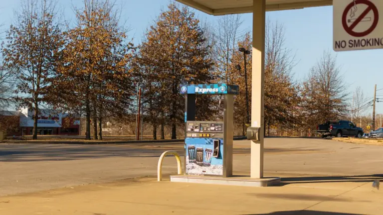 Une pompe à essence isolée dans une station-service par une journée ensoleillée.