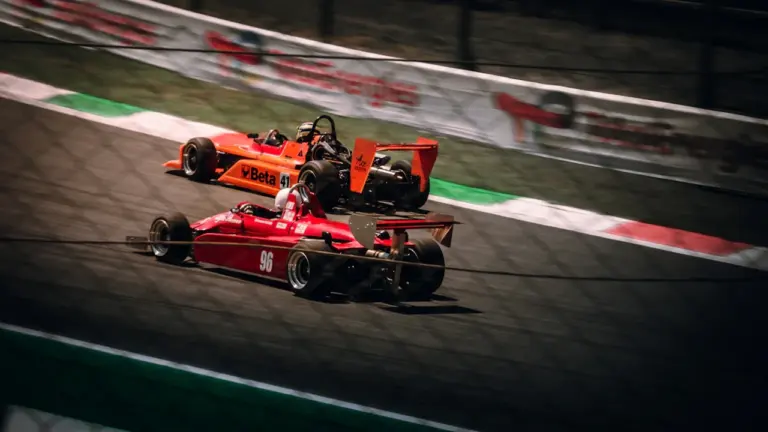 Deux voitures de course en pleine action sur le circuit rapide de Monza, Italie.