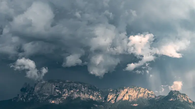 Des nuages d'orage menaçants au-dessus d'une chaîne de montagnes escarpée.