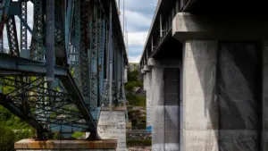 Vue structurelle d'un pont en acier traversant une rivière, rappelant l'architecture urbaine parisienne.