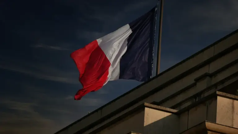 Drapeau français flottant dans le ciel bleu au-dessus de Paris.