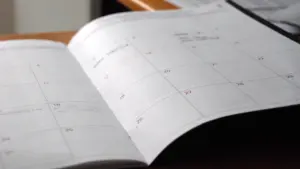 Un agenda ouvert sur un bureau pour organiser la rentrée scolaire.