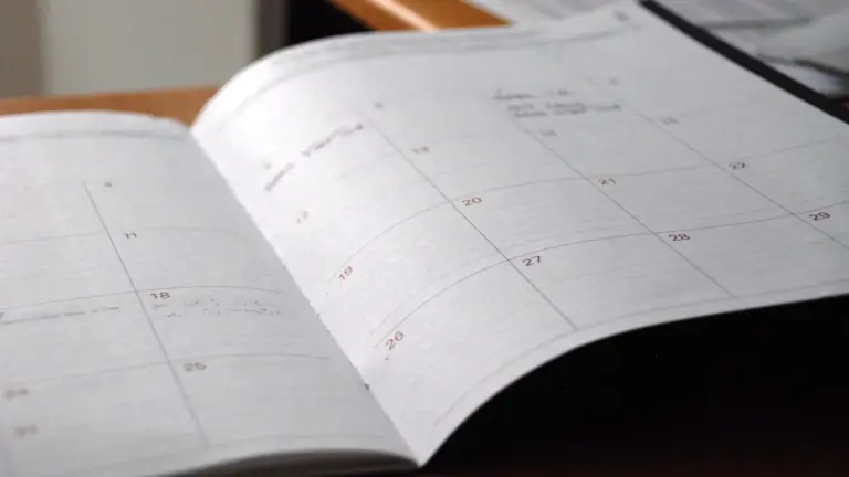 Un agenda ouvert sur un bureau pour organiser la rentrée scolaire.