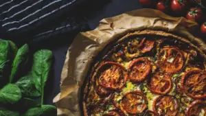 Tarte rustique aux tomates cerises et herbes fraîches sur papier cuisson
