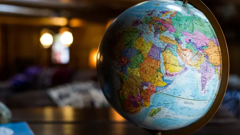 Un globe terrestre éclairé posé sur une table pour illustrer les voyages internationaux.