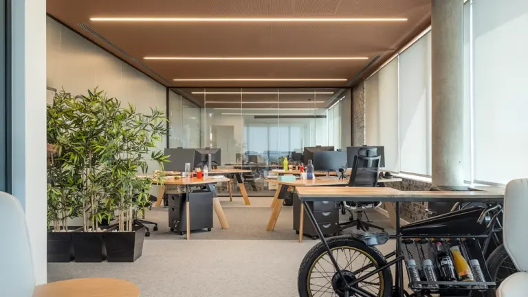 Un espace de bureau moderne et épuré avec un vélo stationnaire au premier plan.