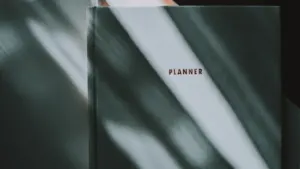 Un carnet de planification fermé posé sur une table avec une lumière douce.