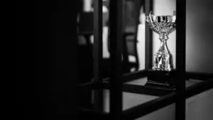 Un trophée argenté élégant placé sur une table dans une salle sombre.