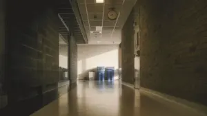 Longue perspective d'un couloir d'établissement scolaire avec des murs en briques.