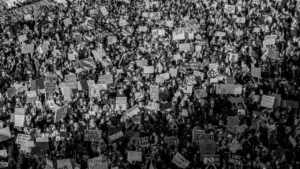 Vue aérienne en noir et blanc d'une manifestation citoyenne avec de nombreuses pancartes.